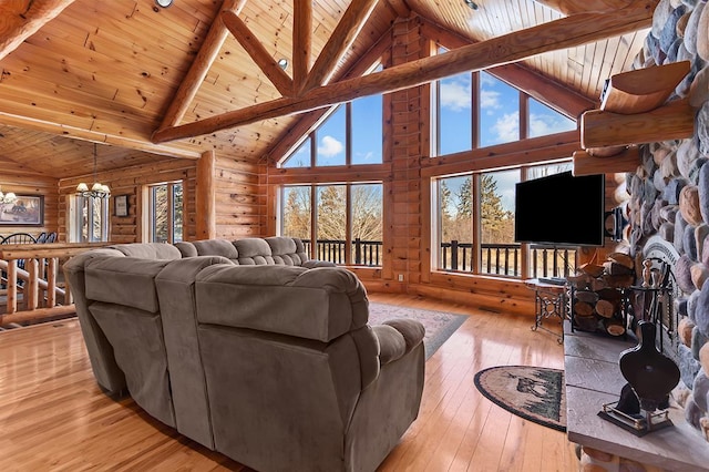 living room with beam ceiling, log walls, wooden ceiling, and light wood-type flooring