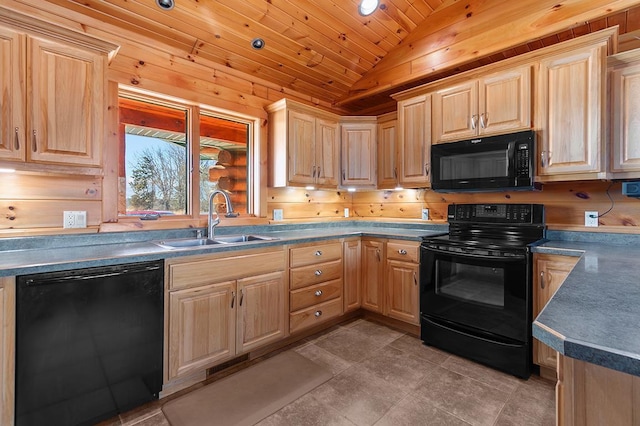 kitchen featuring light brown cabinetry, wood walls, lofted ceiling, sink, and black appliances