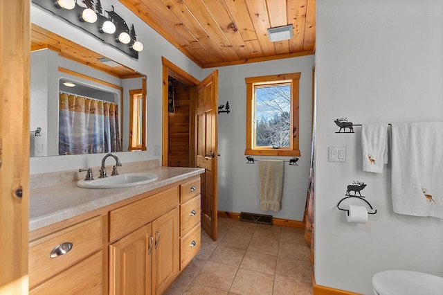 bathroom with wood ceiling, vanity, ornamental molding, tile patterned floors, and toilet