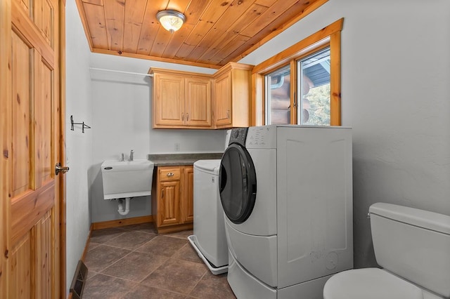 clothes washing area featuring sink, wooden ceiling, and washing machine and clothes dryer