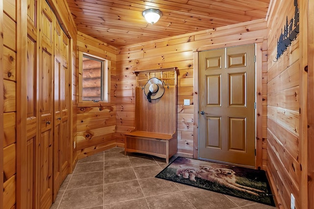 mudroom featuring wooden ceiling and wooden walls