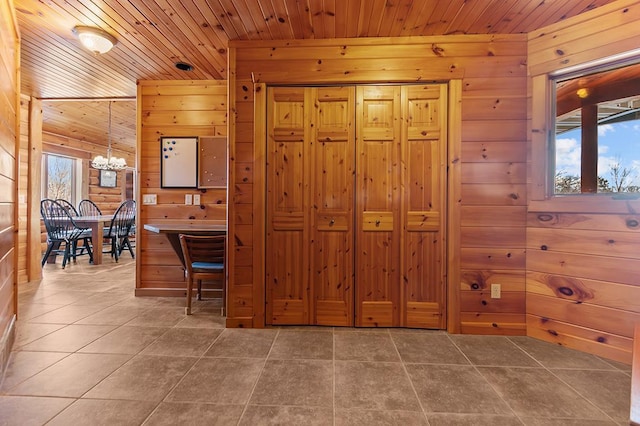 interior space featuring an inviting chandelier, wood ceiling, and wood walls