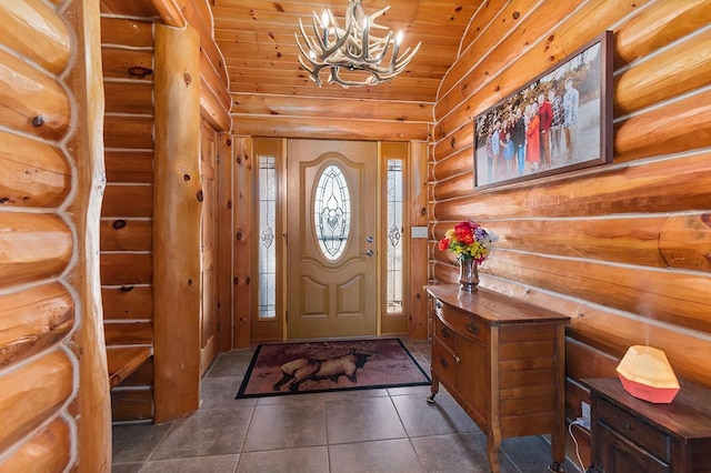 tiled entrance foyer featuring lofted ceiling, a notable chandelier, log walls, and wooden ceiling