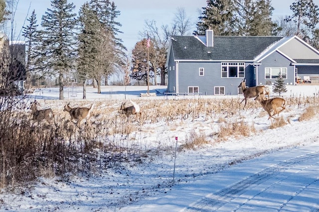 view of snow covered back of property