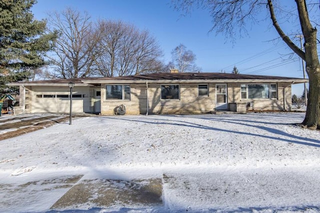 snow covered back of property with a garage