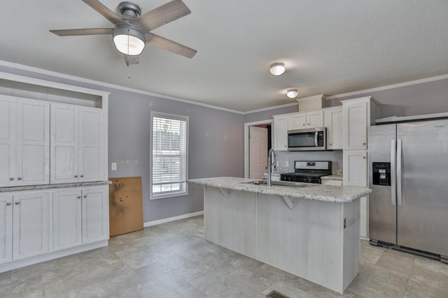 kitchen with sink, ornamental molding, appliances with stainless steel finishes, an island with sink, and white cabinets