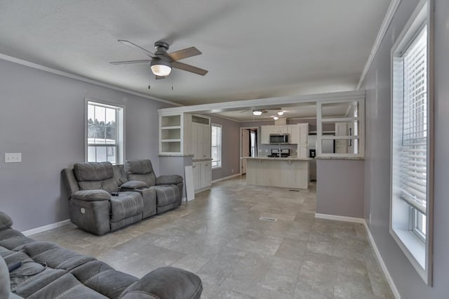 living room with crown molding and ceiling fan