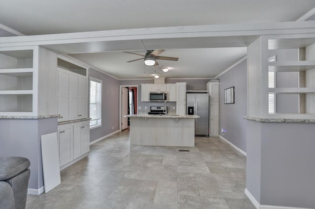 kitchen with white cabinetry, ornamental molding, appliances with stainless steel finishes, and a kitchen island