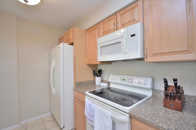 kitchen featuring light stone counters, light tile patterned floors, white appliances, and light brown cabinets