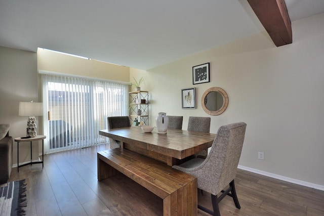 dining space with beamed ceiling and dark hardwood / wood-style floors