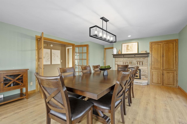 dining room featuring a fireplace and light hardwood / wood-style floors