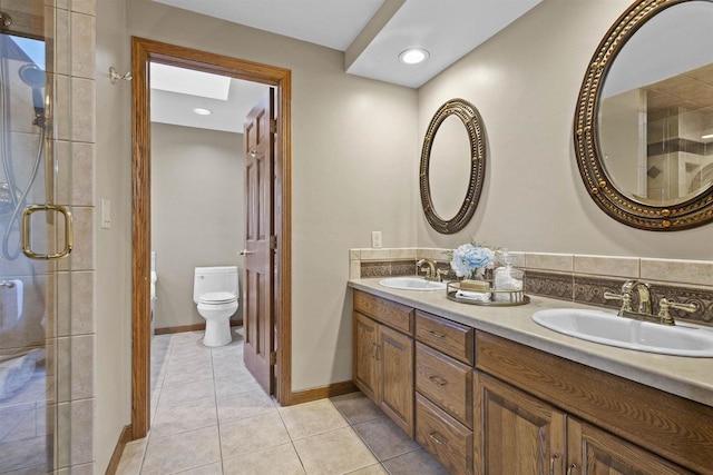 bathroom featuring tile patterned flooring, vanity, a shower with door, and toilet