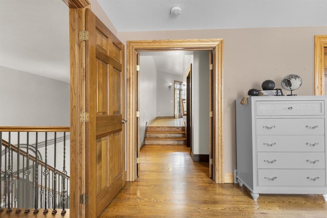 hallway with vaulted ceiling and light hardwood / wood-style flooring