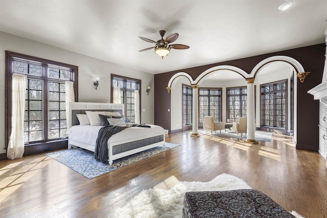 bedroom with multiple windows, hardwood / wood-style flooring, and ceiling fan