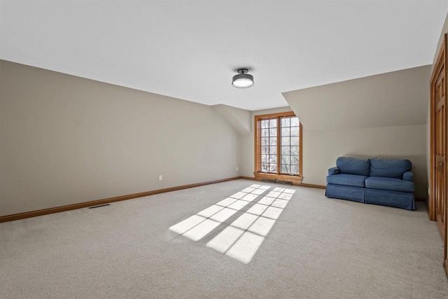 bonus room with light colored carpet and lofted ceiling