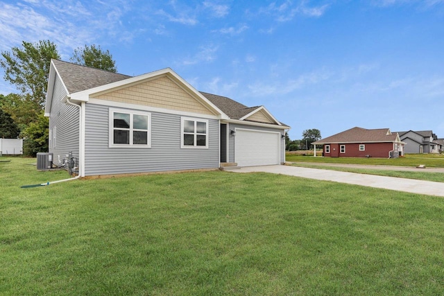 view of front of house with a garage, central AC, and a front lawn