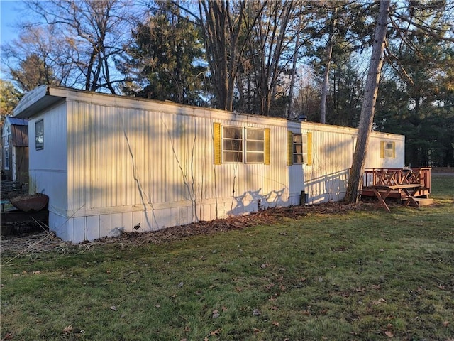 view of side of property featuring a wooden deck and a yard