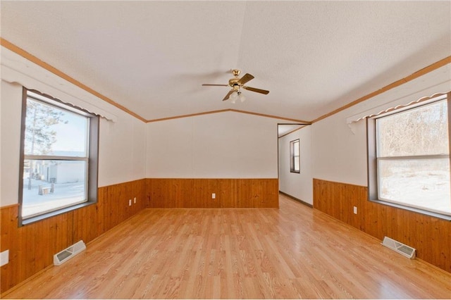 2218 10 1/8 Ave, Chetek, WI 54728 - spare room with a wealth of natural light, wooden walls, and light hardwood / wood-style floors