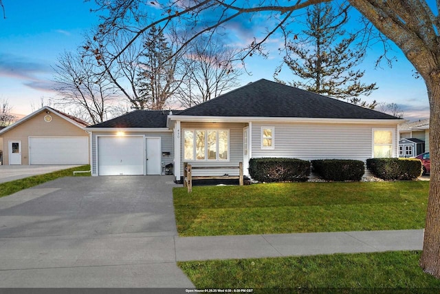 ranch-style house featuring a garage and a lawn