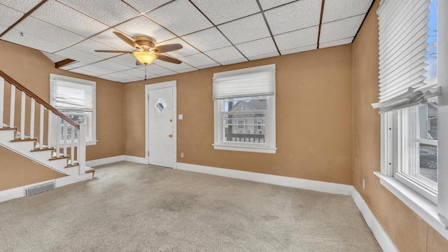 carpeted entryway with ceiling fan and a drop ceiling