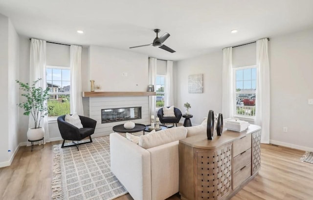 living room with ceiling fan and light wood-type flooring