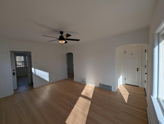 spare room with baseboard heating, ceiling fan, and light hardwood / wood-style flooring