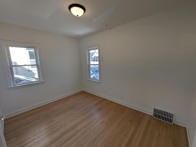 empty room with a healthy amount of sunlight and light hardwood / wood-style floors