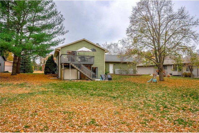 back of property featuring a wooden deck and a yard