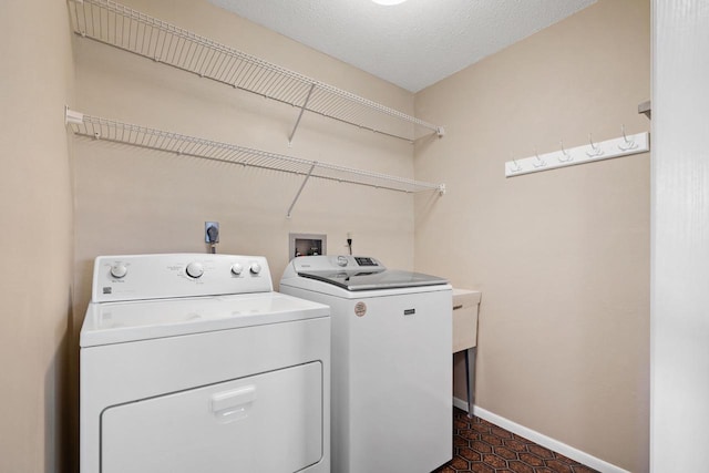 laundry area featuring washer and clothes dryer and a textured ceiling