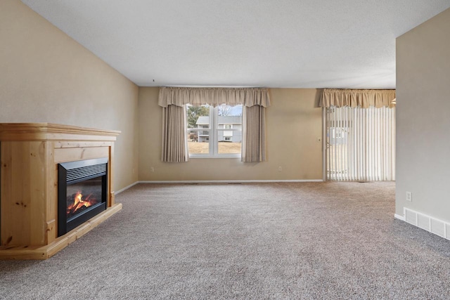 unfurnished living room featuring carpet flooring and a textured ceiling