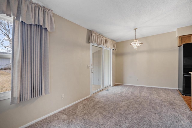 unfurnished living room featuring carpet flooring and a textured ceiling