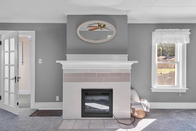 room details featuring a fireplace, ornamental molding, ceiling fan, and carpet flooring