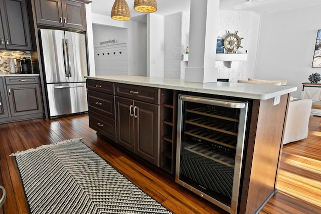 kitchen featuring dark wood-type flooring, stainless steel fridge, beverage cooler, and decorative backsplash