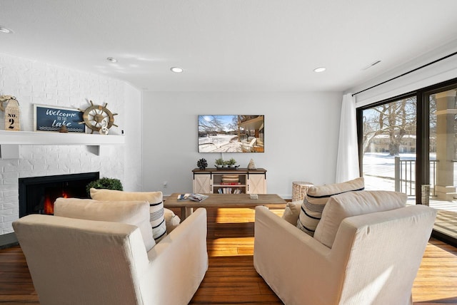 living room with hardwood / wood-style flooring and a brick fireplace