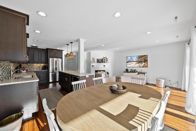 dining area with decorative columns, sink, and dark hardwood / wood-style flooring