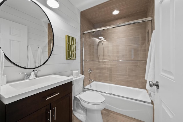 full bathroom with vanity, toilet, combined bath / shower with glass door, and hardwood / wood-style floors