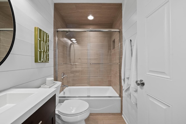 full bathroom featuring vanity, shower / bath combination with glass door, and toilet