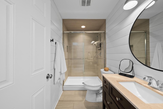 bathroom featuring an enclosed shower, vanity, toilet, and wood walls