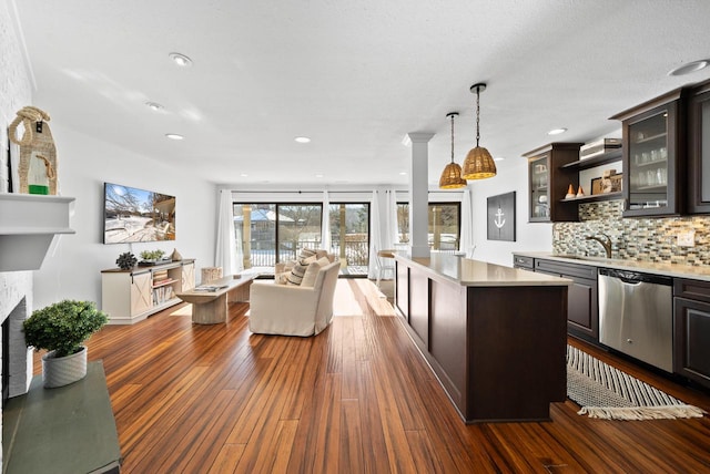 kitchen with a center island, dark brown cabinets, dishwasher, pendant lighting, and backsplash