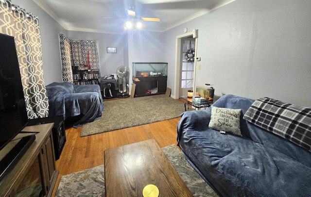 living room with wood-type flooring, crown molding, and ceiling fan