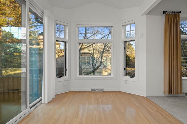 unfurnished sunroom featuring lofted ceiling