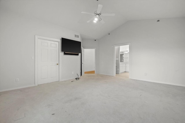 unfurnished bedroom with vaulted ceiling, connected bathroom, light colored carpet, and ceiling fan