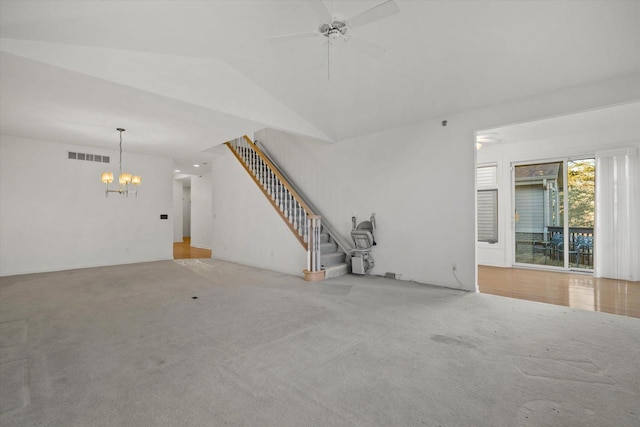 unfurnished living room featuring vaulted ceiling, carpet, and ceiling fan with notable chandelier