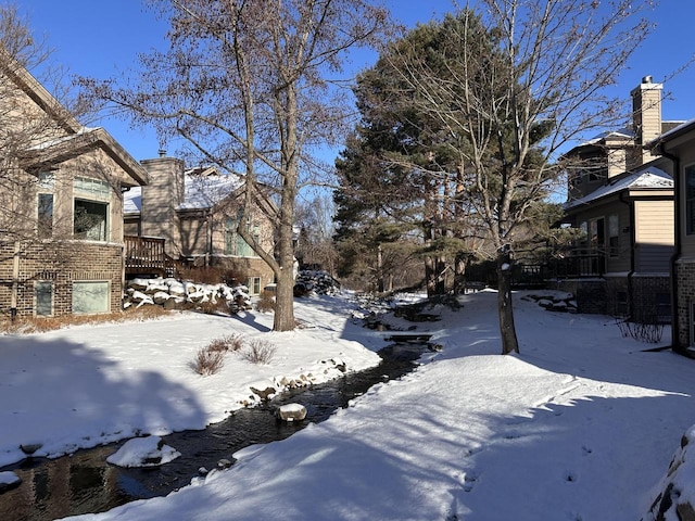 yard covered in snow with a wooden deck