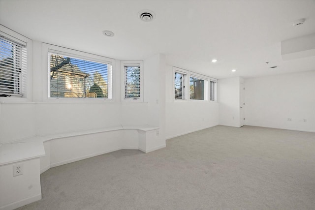 empty room featuring light carpet and plenty of natural light