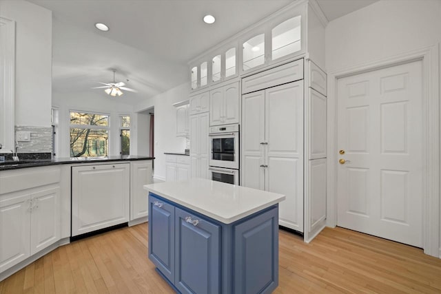 kitchen with white cabinetry, a kitchen island, and light hardwood / wood-style floors