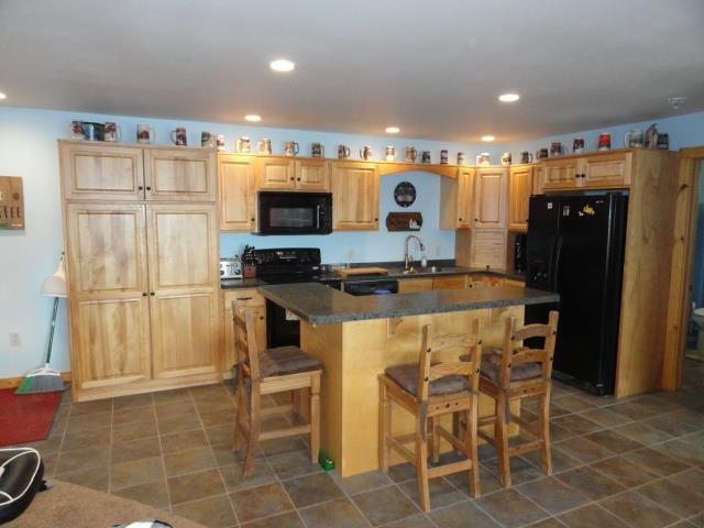N8621 5th Rd, Westfield, WI 53964 - kitchen with a center island, sink, light brown cabinetry, and black appliances