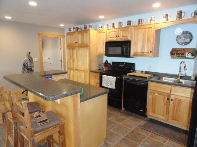 N8621 5th Rd, Westfield, WI 53964 - kitchen featuring light brown cabinetry, a breakfast bar, sink, a kitchen island, and black appliances