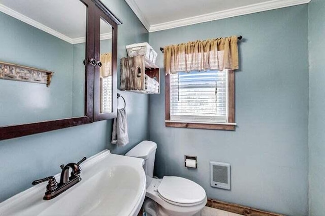 bathroom featuring crown molding, sink, heating unit, and toilet