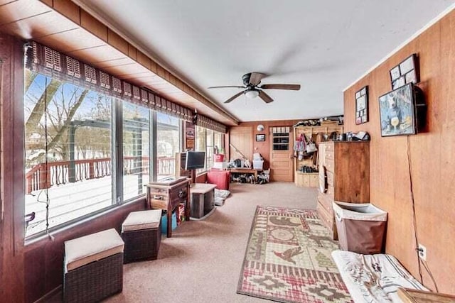 interior space featuring ceiling fan, carpet floors, and wooden walls